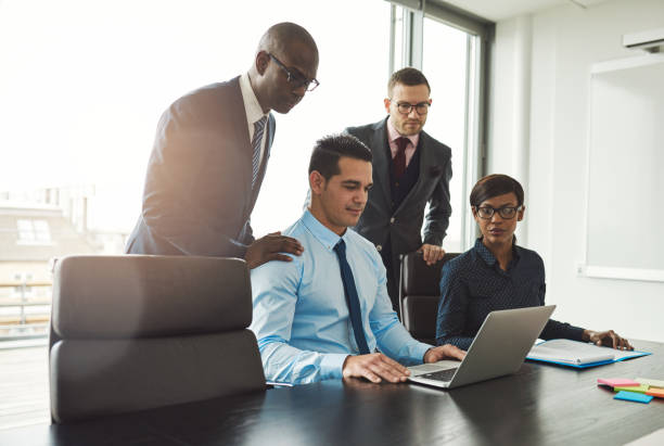 istock Friendly group of professionals looking at laptop 607281020