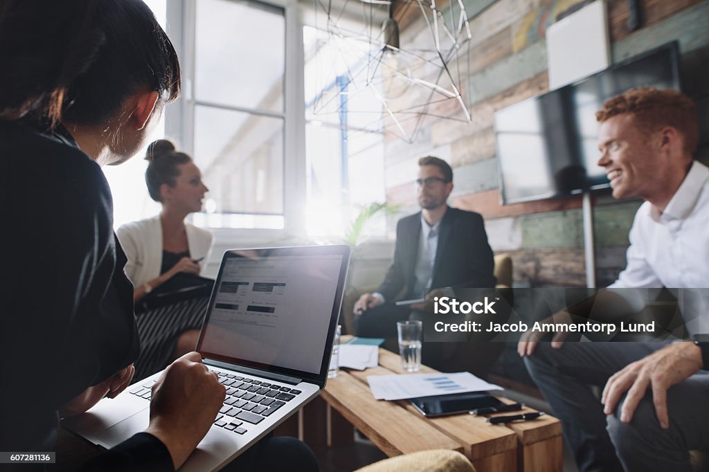 Empresaria trabajando en laptop en reunión - Foto de stock de Negocio libre de derechos