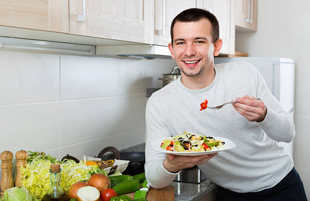 istock Cheerful  handsome man holding plate with salad 607281650