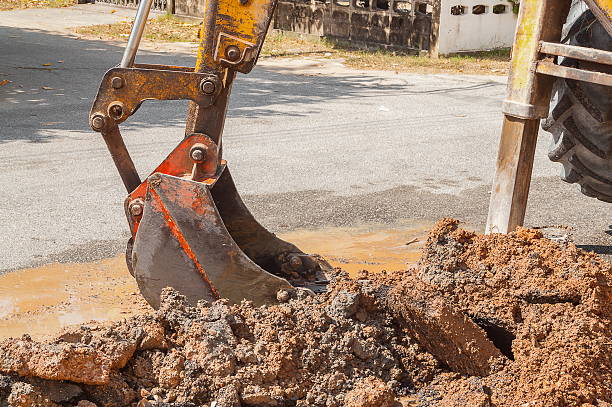 istock Excavator working the Repair of  pipe on  road 607282952