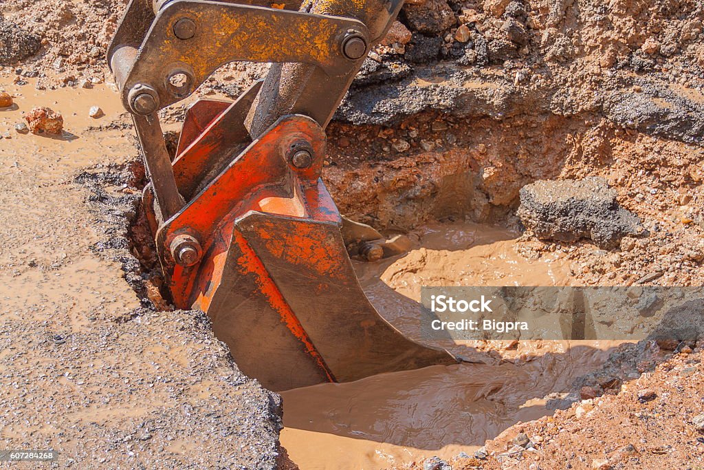 Excavator working the Repair of  pipe on  road Excavator working on the Repair of  pipe water and sewerage on road, Worker using a small excavator to dig a hole to fix a water. Agricultural Machinery Stock Photo