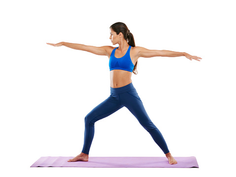 Shot of a sporty young woman practicing yoga against a white background