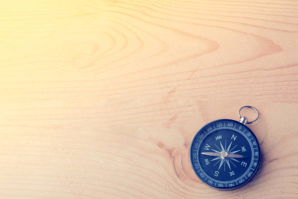 istock Compass on vintage wooden background. 607285072