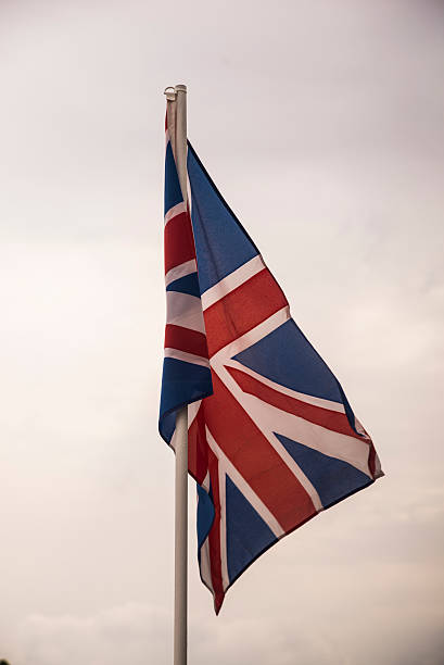 istock Flag of britain under blue sky 607285562