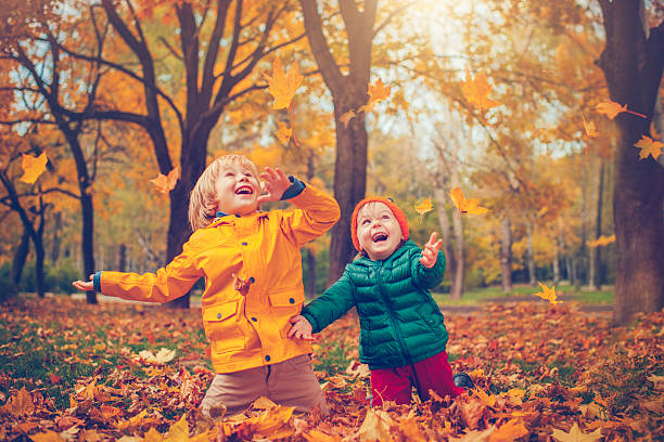 little boy and girl in autumn park - smiling little girls little boys autumn imagens e fotografias de stock