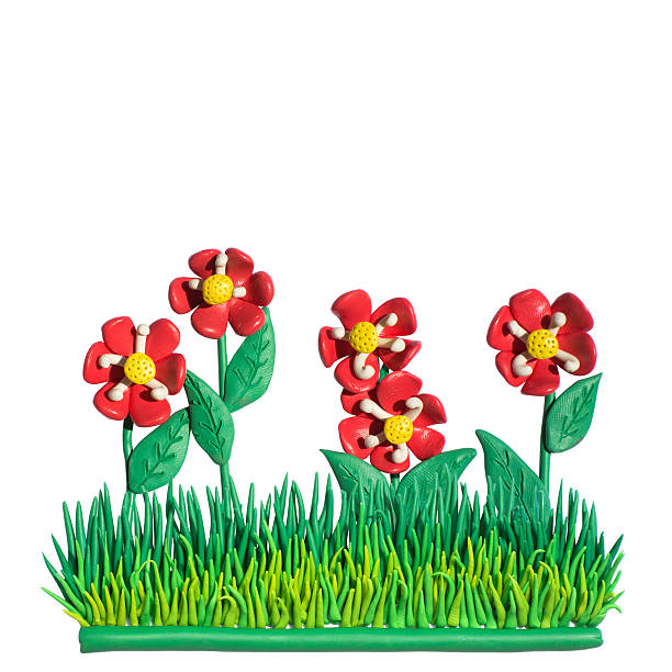 Clay putty, plasticine handmade flowers in green grass. Nature background with handmade objects isolated on the white background.