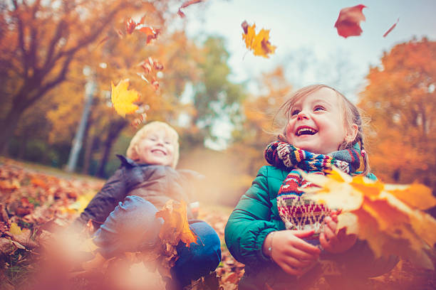 little boy and girl in autumn park - smiling little girls little boys autumn imagens e fotografias de stock