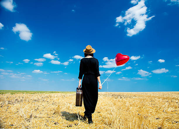 istock young woman with suitcase and balloon 607288430