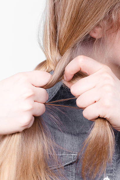 istock Blonde woman making braid tress. 607288590