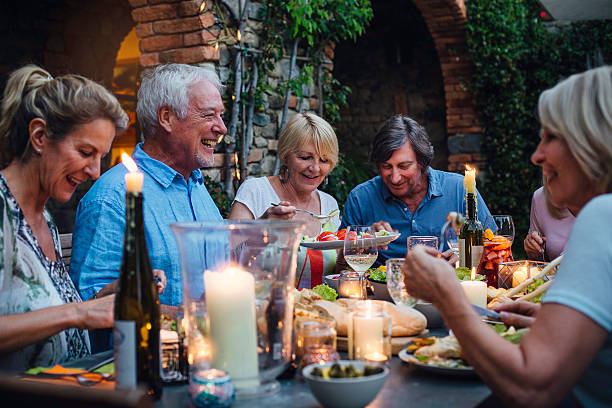 al fresco dining à la chandelle - dining senior adult friendship mature adult photos et images de collection