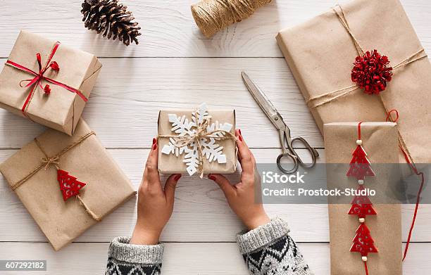 Las Manos De La Mujer Envolviendo El Regalo De Vacaciones De Navidad Con Cordel Artesanal Foto de stock y más banco de imágenes de Papel de envolver