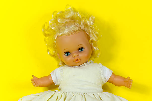 vintage doll, dolly, puppet,  old toy, retro, yellow background , blue eyes, blond hair, infant, infantile, childish