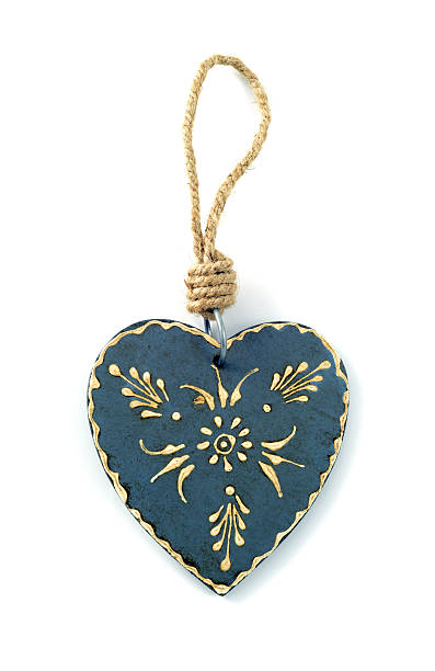 istock wooden heart with white paintings hanging on white isolated background 607295314