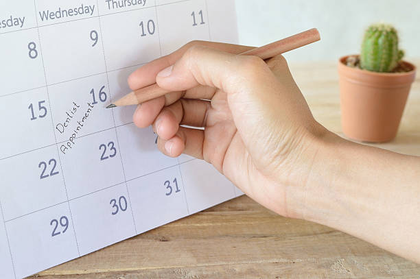 istock woman write dentist appointment in calendar planner 607295438