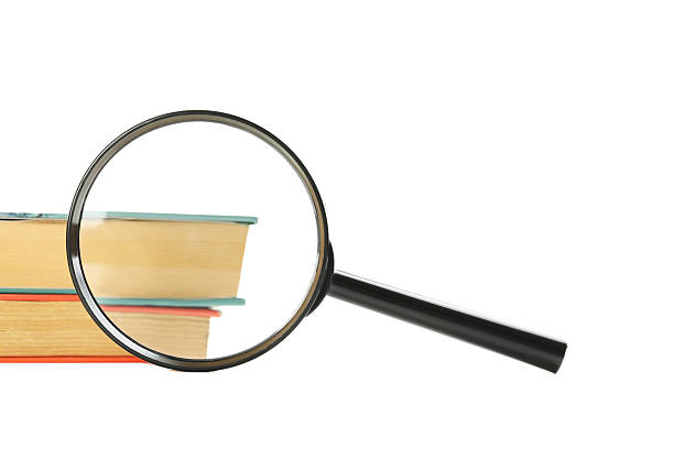istock Magnifying glass wtih books isolated on a white 607295760