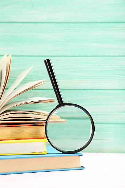 istock Magnifying glass on a pink wooden table 607295834