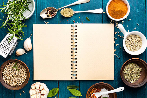 sfondo culinario con spezie e ricettario - spice kitchen utensil herb curry powder foto e immagini stock