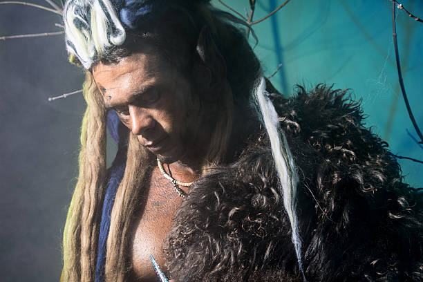 Portrait of pensive man werewolf with a skin on the shoulder and with dreadlocks