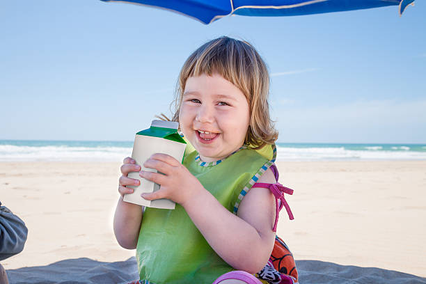 istock little child with beverage container in hands at beach 607301292