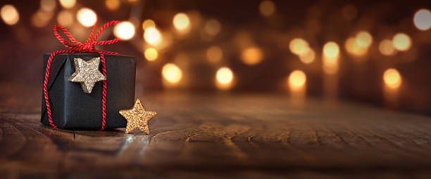 Christmas background with a gift Festive shining Christmas background with a gift and bokeh stars in your eyes stock pictures, royalty-free photos & images