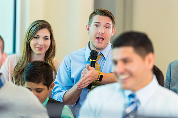 istock Concerned Caucasian man asks a question during political meeting 607460024