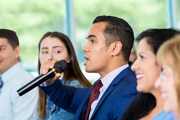 istock Concerned Hispanic citizen asks political candidate a question during meeting 607460034