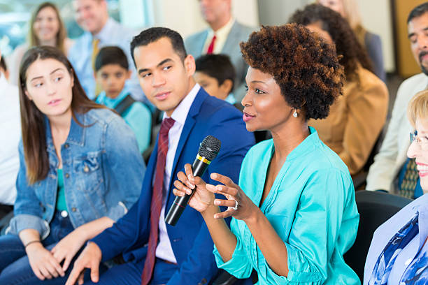 自信に満ちたアフリカ系アメリカ人女性が会議中に質問をする - talking to audience ストックフォトと画像