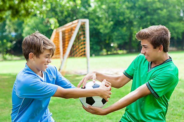 istock Opposing soccer team players fight over ball 607460334
