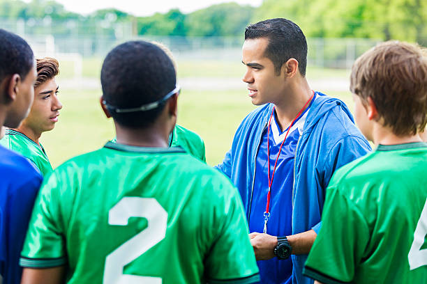 istock Serious coach talks with players before soccer game 607460362