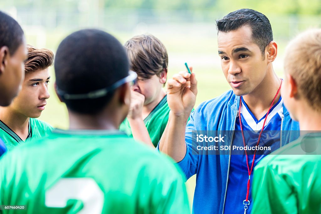 Fokussierter Fußballtrainer gibt Spielern einen Pep-Talk - Lizenzfrei Trainer Stock-Foto