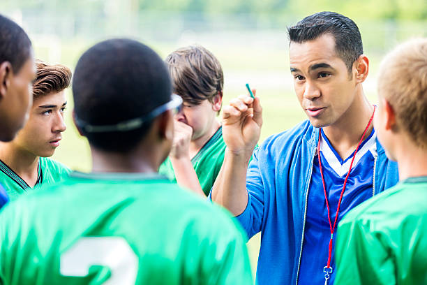 Focused soccer coach gives players a pep talk