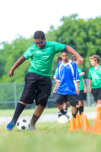 istock Active African American soccer player kicks ball 607460448