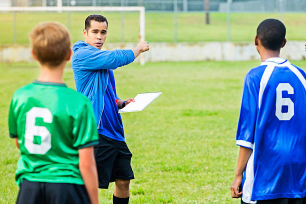 istock Boys soccer coach instructs players during game 607460464