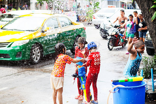 счастливые тайские дети с большой водяной пушкой - bangkok thailand asia water taxi стоковые фото и изображения