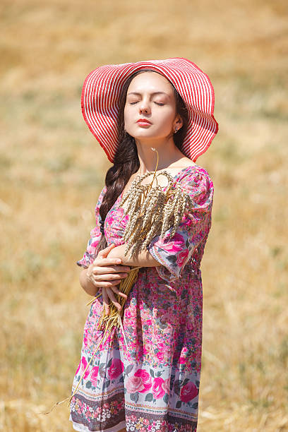 istock girl in hat on wheat field 607466866