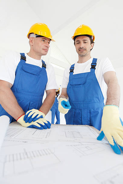 istock Team of buildres with plan 607466920