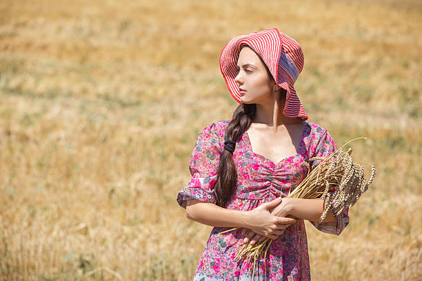 istock girl in hat on wheat field 607467320