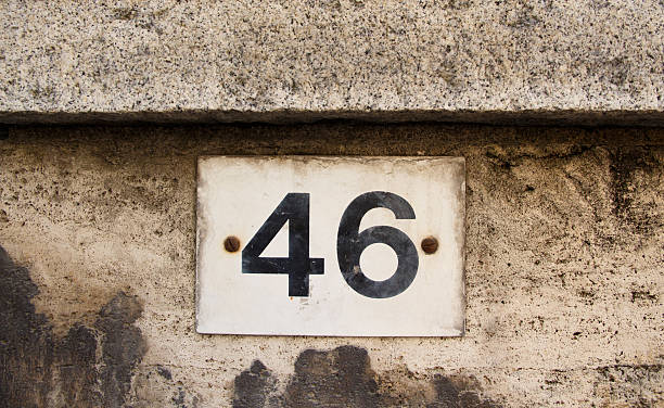 istock Number forty six on the grey stone wall 607468192