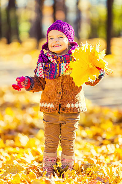 istock Little girl playing with autumn leaves 607468356