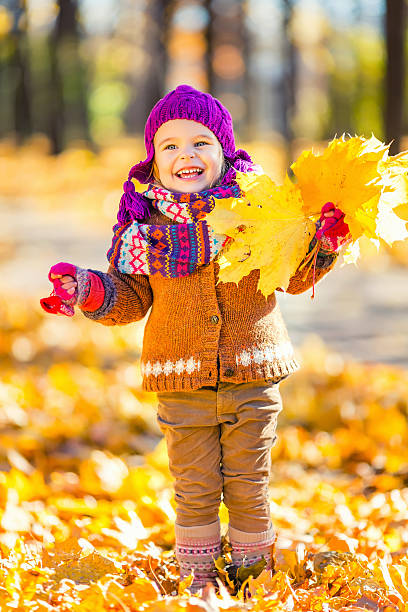 istock Little girl playing with autumn leaves 607468424