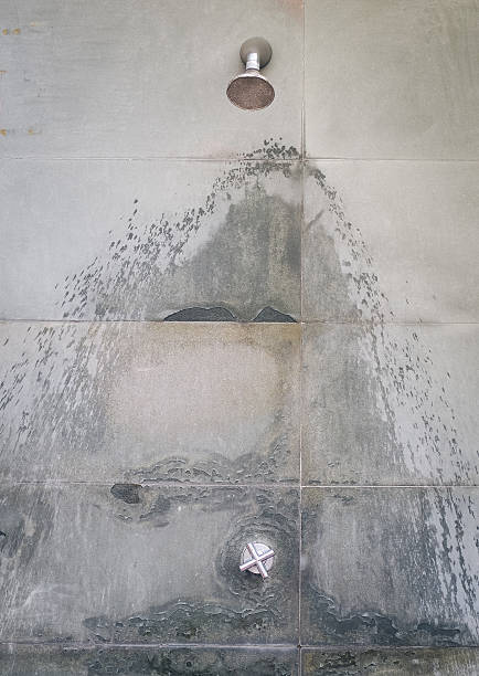 istock Old shower head and water valve mounted on the old wall 607470302
