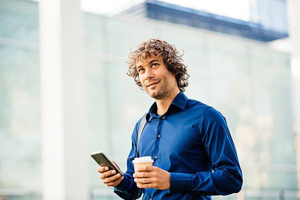 istock Businessman with coffee and smartphone in morning 607471422
