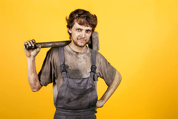 istock Handsome smiling mechanic hammer yellow dirty 607476366