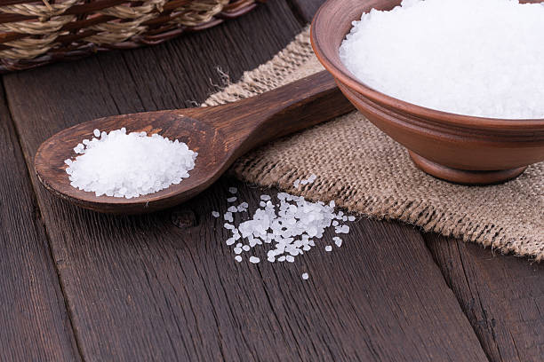 istock Sea salt in a ceramic bowl on old wooden table. 607476810