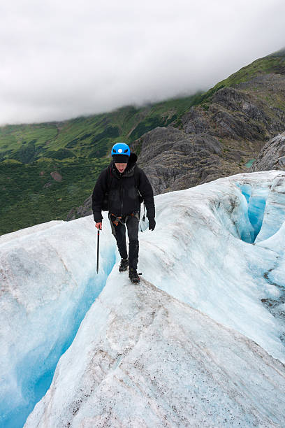 istock Risky walk between crevasses on icy glacier 607480562