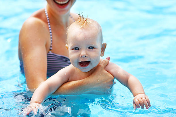 istock mother teaching baby swimming pool 607482530