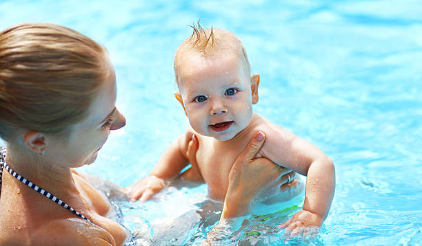 istock mother teaching baby swimming pool 607482654