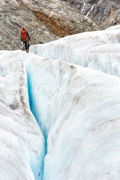 istock Back view of man walking between crevasses 607482856