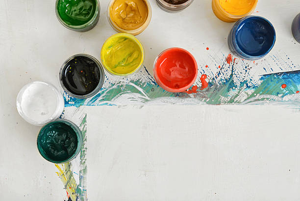 istock Artist's workplace with paper and jars of different paint 607484550