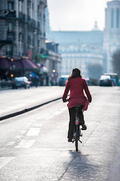 istock French woman riding bicycle on Paris street 607487936